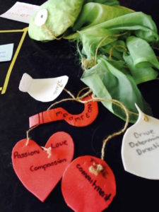 A series of post-it notes, red hearts and green ribbon