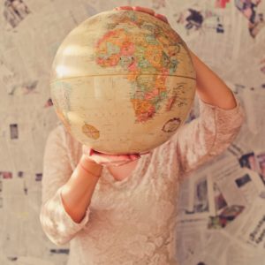 a person holds a large globe in front of their head